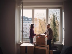 En man och en kvinna står i ett rum med lådor. Väntar på tips om hur man ska flyttpacka sin lägenhet.